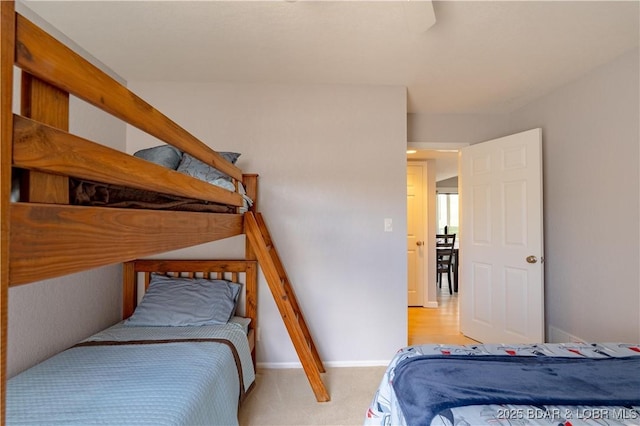 bedroom featuring light colored carpet and baseboards