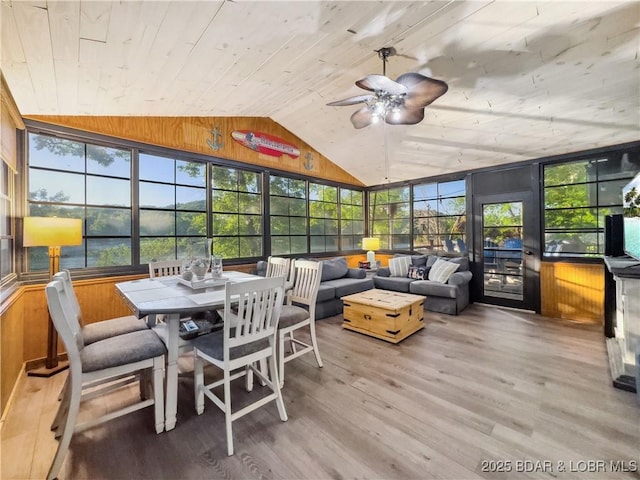 sunroom / solarium with wooden walls, wood finished floors, wooden ceiling, high vaulted ceiling, and a deck