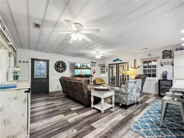 living area featuring a ceiling fan, dark wood-style floors, crown molding, and wine cooler