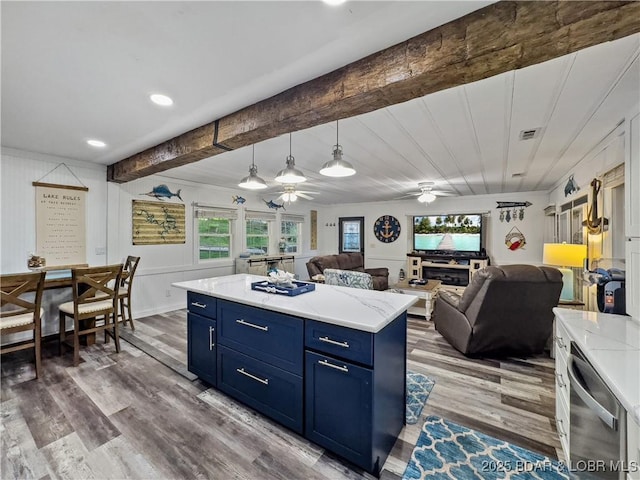 kitchen with blue cabinets, a ceiling fan, beam ceiling, wood finished floors, and open floor plan