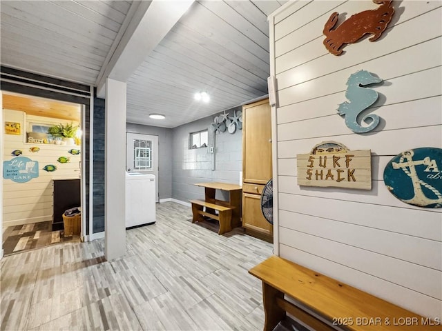 mudroom featuring wooden walls, light wood-style flooring, and wood ceiling