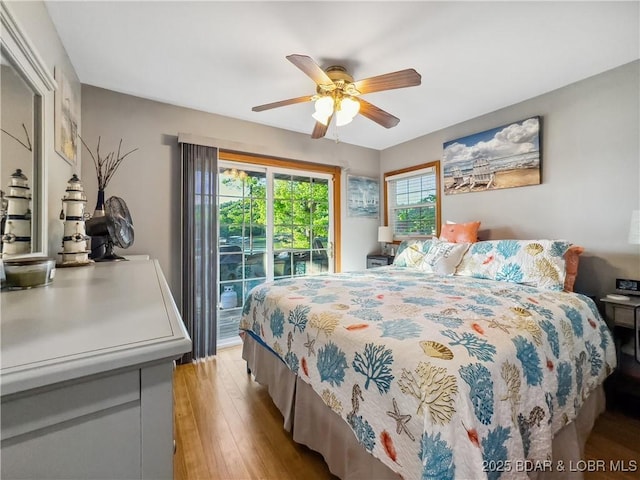 bedroom with access to outside, wood finished floors, and ceiling fan