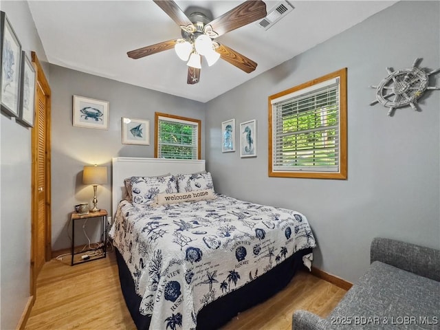 bedroom featuring wood finished floors, baseboards, and ceiling fan