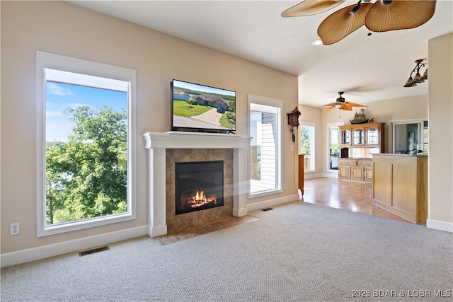 22714 Lake Ridge Dr, Warsaw, MO 65355 - unfurnished living room with a ceiling fan, a tiled fireplace, healthy amount of natural light, and carpet floors