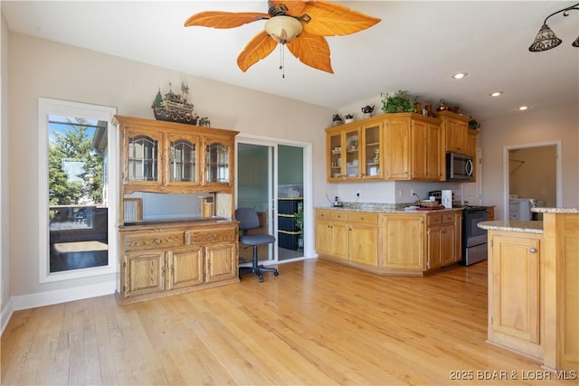 22714 Lake Ridge Dr, Warsaw, MO 65355 - kitchen with stainless steel microwave, black / electric stove, light wood-style flooring, glass insert cabinets, and a ceiling fan