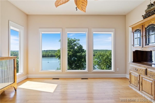22714 Lake Ridge Dr, Warsaw, MO 65355 - unfurnished living room with healthy amount of natural light, light wood-style flooring, and baseboards