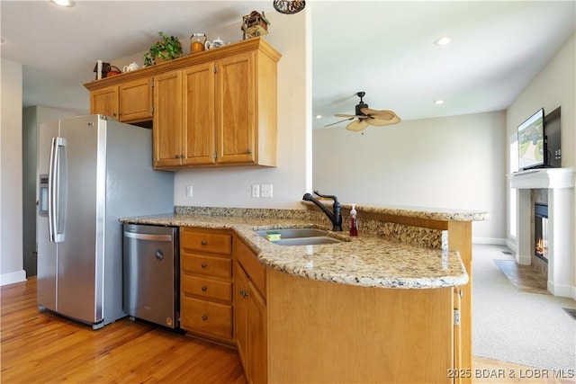 22714 Lake Ridge Dr, Warsaw, MO 65355 - kitchen with a sink, stainless steel appliances, a peninsula, a ceiling fan, and light stone countertops