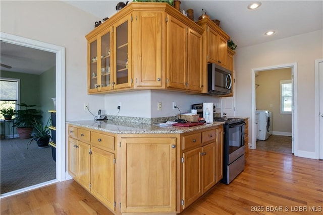 22714 Lake Ridge Dr, Warsaw, MO 65355 - kitchen with stainless steel microwave, electric range, light wood finished floors, glass insert cabinets, and baseboards