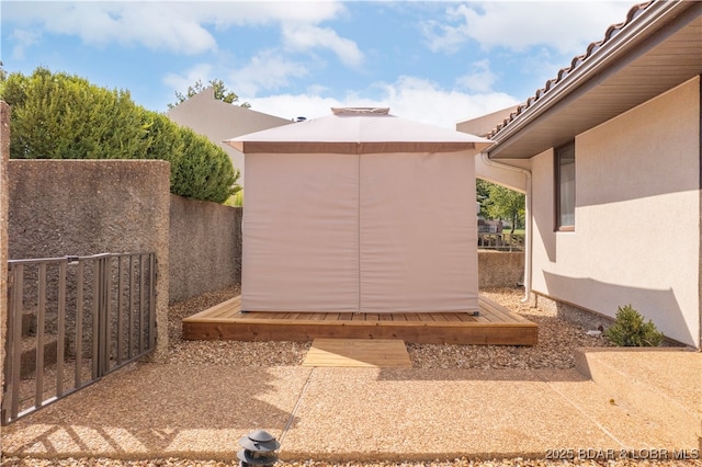 view of patio / terrace with fence and an outbuilding
