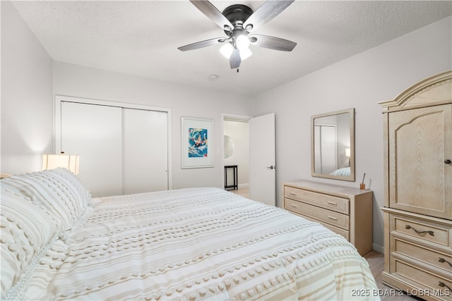 bedroom featuring a closet, light wood-style floors, a textured ceiling, and ceiling fan