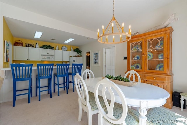 dining area featuring a chandelier and light colored carpet