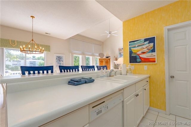 kitchen with white dishwasher, a sink, a chandelier, hanging light fixtures, and light countertops
