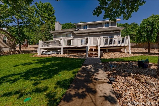 rear view of property with a wooden deck, a lawn, and a chimney