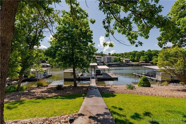 dock area with a water view and a lawn