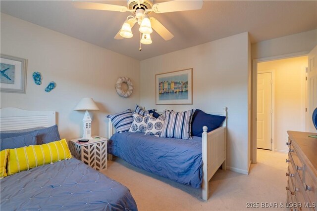 bedroom featuring light colored carpet, a ceiling fan, and baseboards
