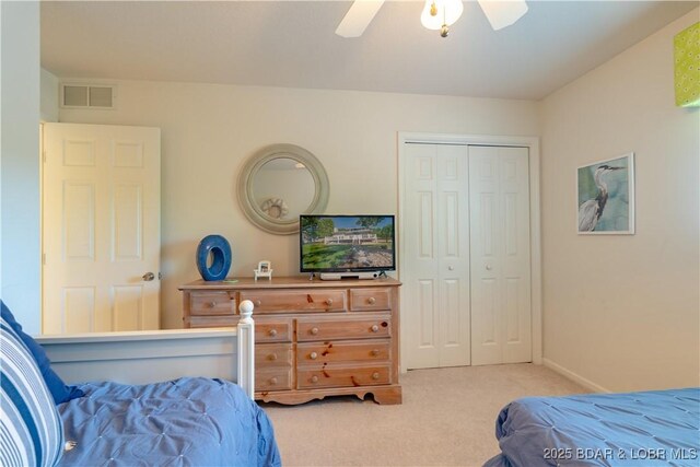 carpeted bedroom with a closet, ceiling fan, and baseboards