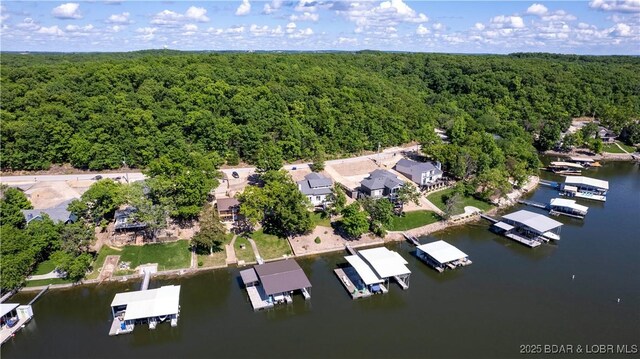 view of property location featuring a heavily wooded area and a nearby body of water