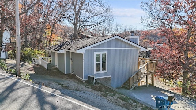 279 Spring Rd, Lake Ozark, MO 65049 - view of side of property featuring stairs, a chimney, and roof with shingles