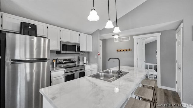 279 Spring Rd, Lake Ozark, MO 65049 - kitchen with stainless steel appliances, a sink, white cabinetry, vaulted ceiling, and dark wood-style flooring