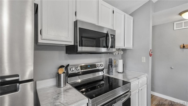 279 Spring Rd, Lake Ozark, MO 65049 - kitchen featuring stainless steel appliances, white cabinets, baseboards, and light stone counters