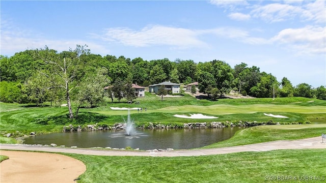 view of community featuring a yard, a water view, and view of golf course