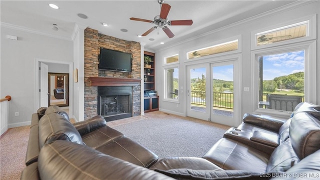carpeted living room featuring crown molding, a stone fireplace, ceiling fan, baseboards, and built in features