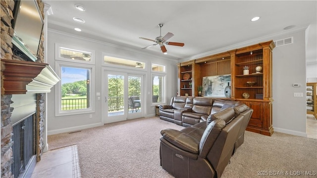 living room featuring a fireplace, crown molding, a ceiling fan, light carpet, and baseboards