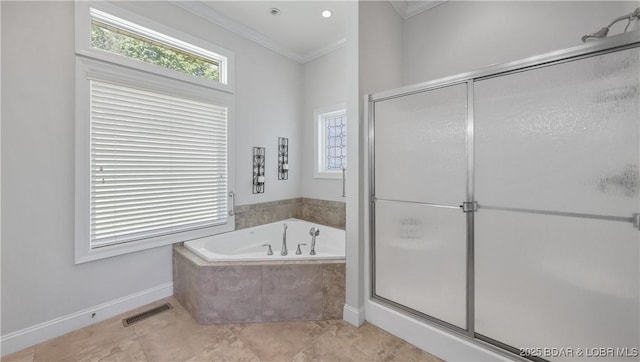 bathroom featuring ornamental molding, a garden tub, a shower stall, and baseboards
