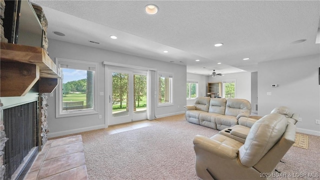 living room with a fireplace with flush hearth, light carpet, a textured ceiling, baseboards, and recessed lighting