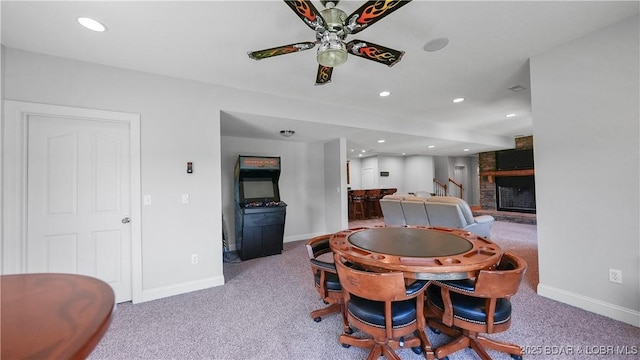 carpeted dining space with baseboards, a ceiling fan, a large fireplace, and recessed lighting