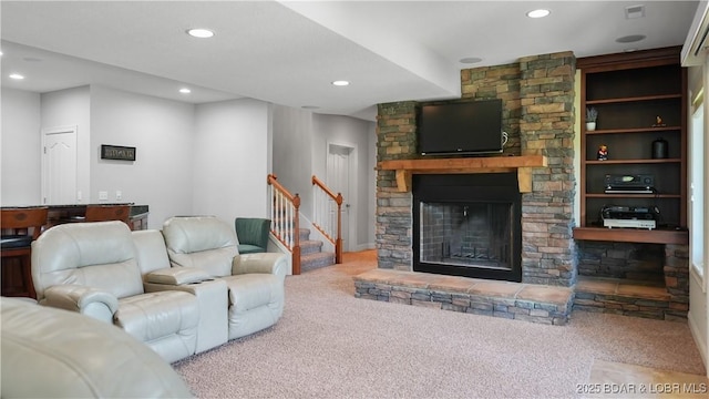 living room with carpet floors, recessed lighting, a stone fireplace, and stairs