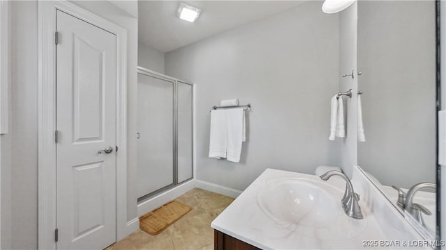 full bathroom featuring a shower stall, vanity, baseboards, and tile patterned floors