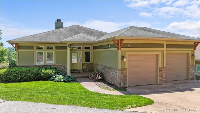 prairie-style home with stone siding, a garage, driveway, and a front lawn