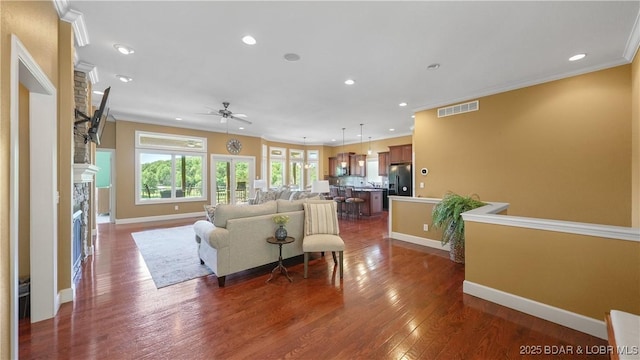 living room featuring ceiling fan, recessed lighting, dark wood-style flooring, baseboards, and ornamental molding