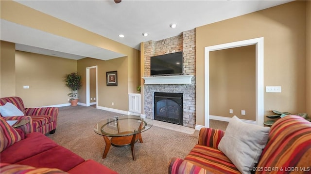 carpeted living area featuring a stone fireplace, baseboards, and recessed lighting
