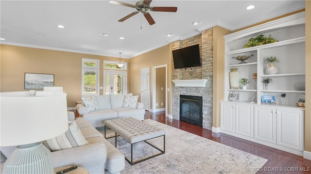 living area featuring dark wood-style flooring, ceiling fan, crown molding, a fireplace, and recessed lighting