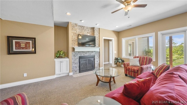 living area with carpet, a stone fireplace, a ceiling fan, baseboards, and recessed lighting