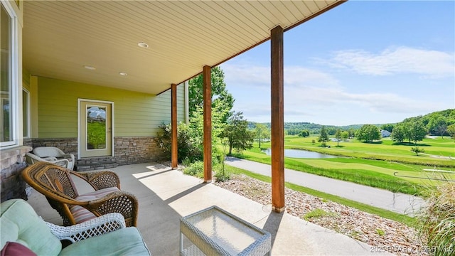 view of patio featuring view of golf course and a water view