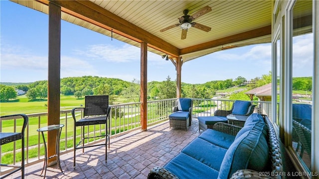 view of patio / terrace featuring a ceiling fan, view of golf course, and a balcony