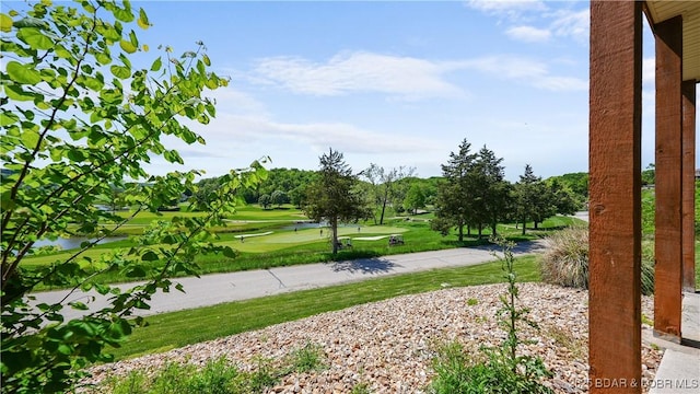 view of property's community featuring view of golf course and a lawn