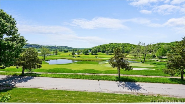 surrounding community featuring view of golf course, a water view, and a lawn