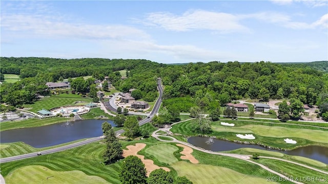 aerial overview of property's location featuring a nearby body of water, a golf course, and a forest