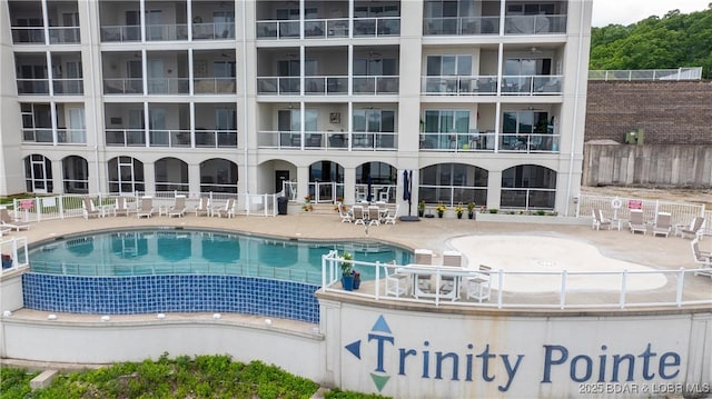 community pool featuring a patio and fence