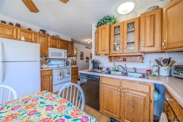 27085 Dixie Ln, Barnett, MO 65011 - kitchen featuring white appliances, a sink, light countertops, light wood-type flooring, and glass insert cabinets