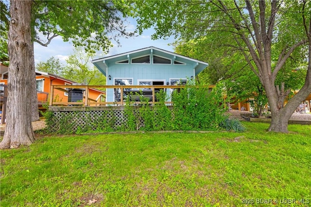 424 Bowers Dr, Camdenton, MO 65020 - back of house featuring board and batten siding, a lawn, and a wooden deck