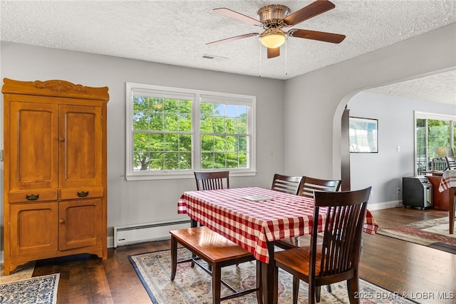 12 Mimosa Rd, Rocky Mount, MO 65072 - dining area with a baseboard heating unit, arched walkways, a textured ceiling, dark wood-style floors, and a ceiling fan