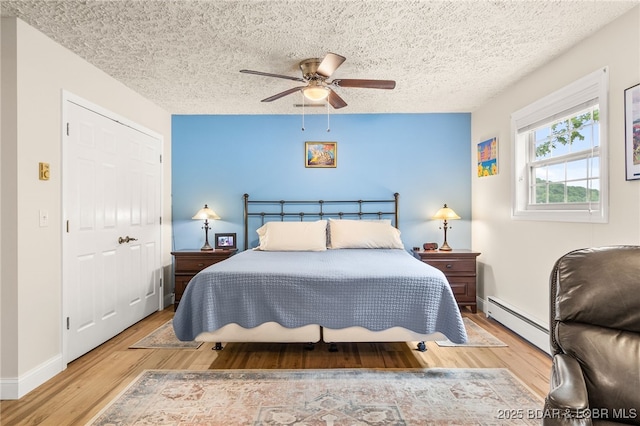 12 Mimosa Rd, Rocky Mount, MO 65072 - bedroom featuring baseboard heating, wood finished floors, a textured ceiling, ceiling fan, and baseboards