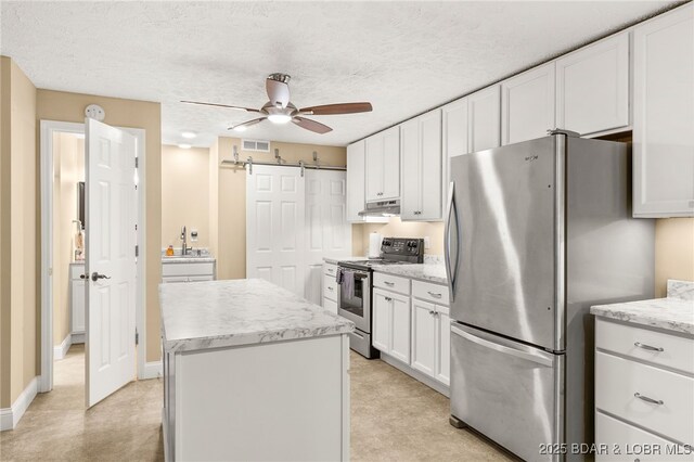 12 Mimosa Rd, Rocky Mount, MO 65072 - kitchen featuring appliances with stainless steel finishes, a ceiling fan, a kitchen island, white cabinets, and a barn door