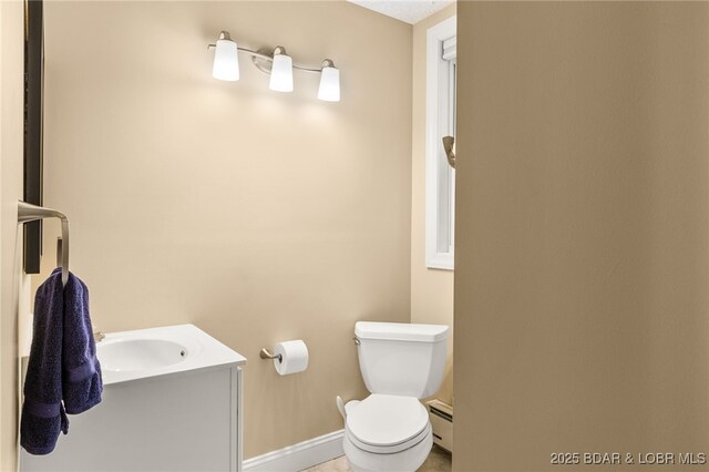 12 Mimosa Rd, Rocky Mount, MO 65072 - bathroom with a baseboard radiator, baseboards, toilet, and vanity