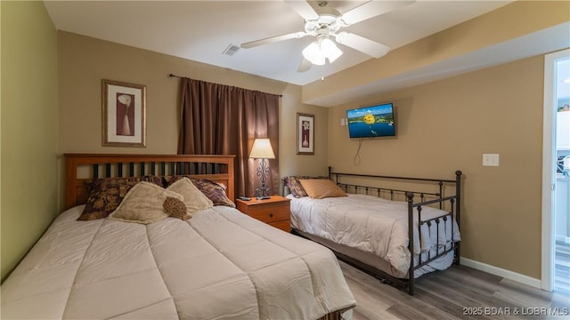 bedroom featuring wood finished floors, baseboards, and a ceiling fan